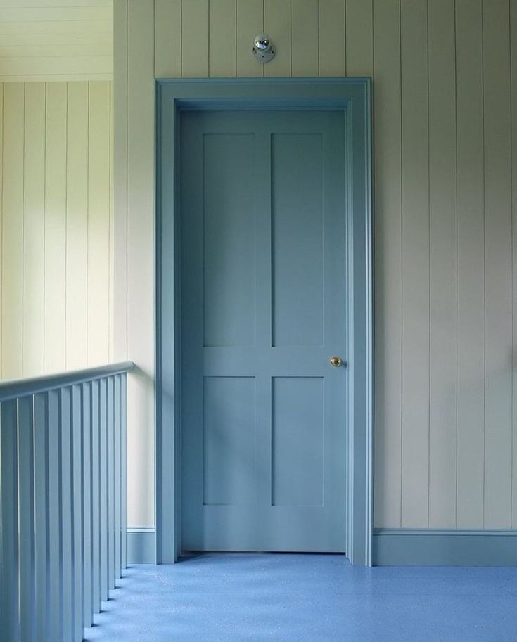 an empty room with a blue door and white walls