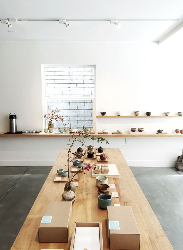 a long wooden table topped with lots of plates and bowls