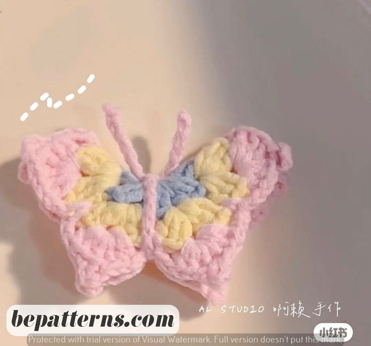 a crocheted butterfly brooch is shown on a white surface with the words beapatterns com written below it