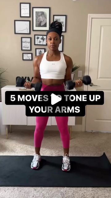 a woman standing on top of a black mat holding two dumbbells