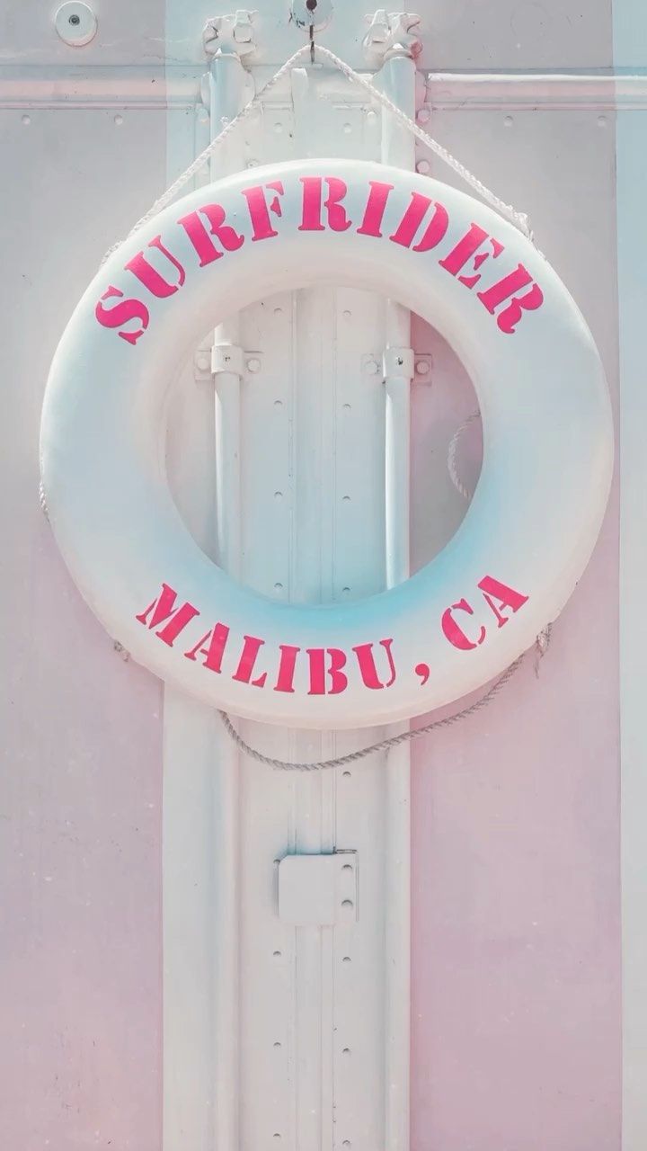 a life preserver on the side of a building with pink paint and white trim