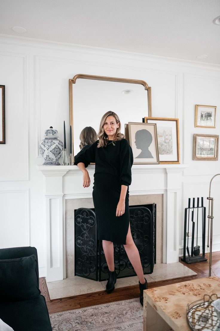 a woman standing in front of a fire place