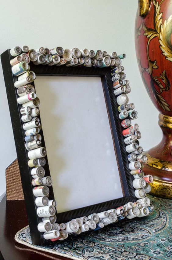 there is a picture frame made out of buttons on the table next to a vase