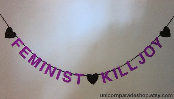 there is a string with hearts on it that says feminist killjoy and hangs from the ceiling