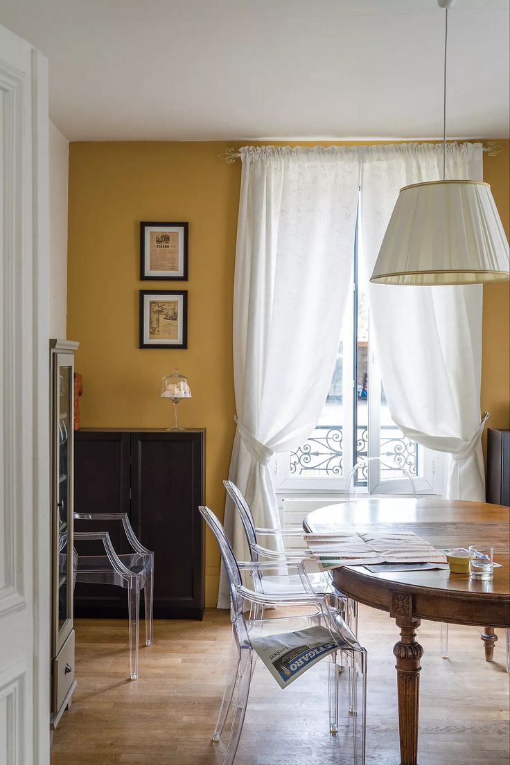 a dining room with yellow walls and chairs