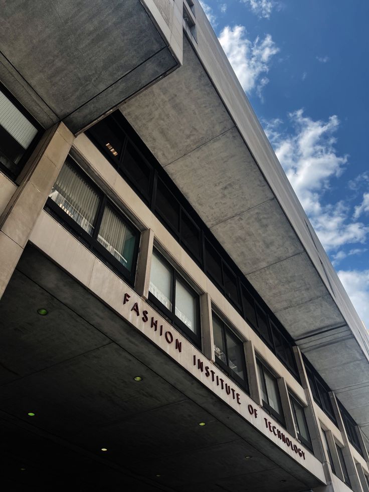 the building has many windows on it and is under a blue sky with white clouds