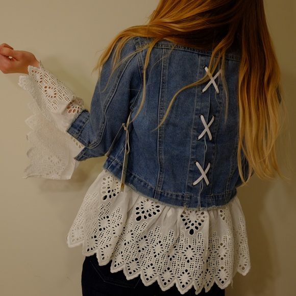 a woman wearing a jean jacket with white lace