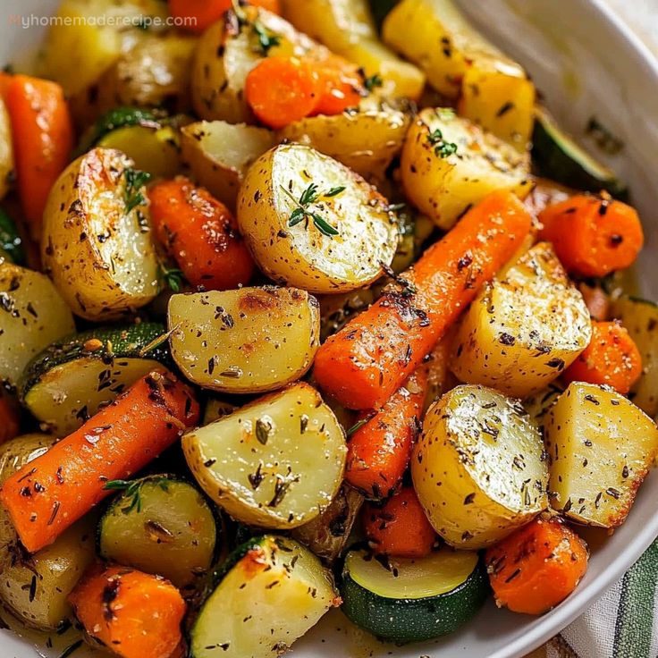 a white bowl filled with potatoes and carrots