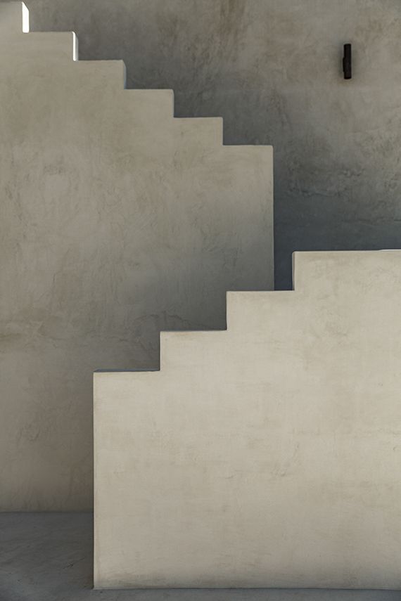 an empty room with stairs leading up to the ceiling