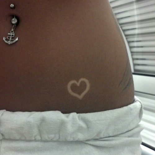 a woman's stomach with a heart and anchor on it