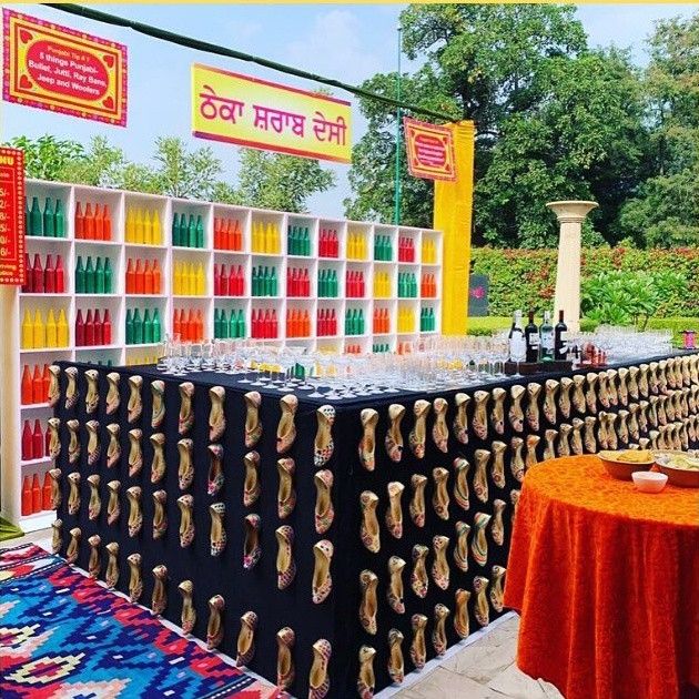 an outdoor event with tables and chairs covered in orange, green, yellow and red cloths