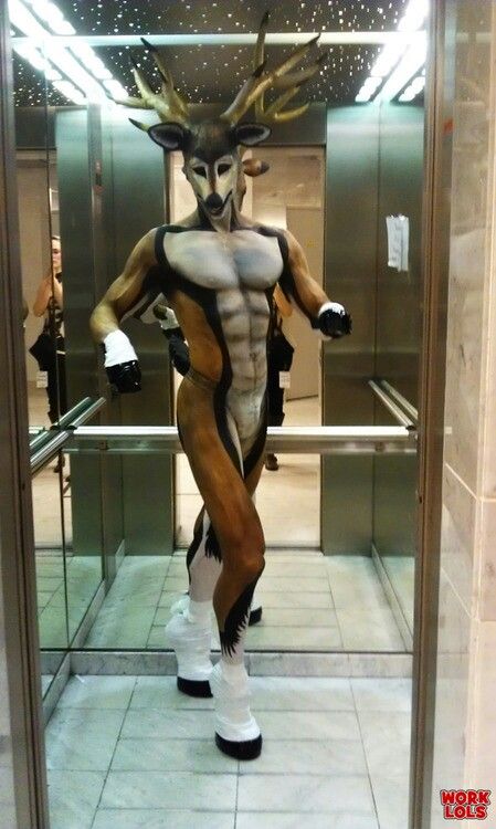 a man dressed up as a deer standing in front of a glass door with his hands on his hips