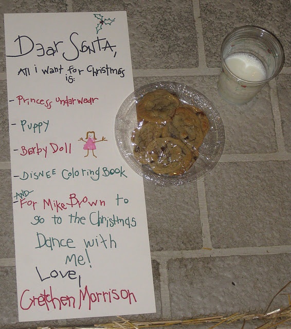 a sign that is on the ground next to a plate with cookies and milk in it