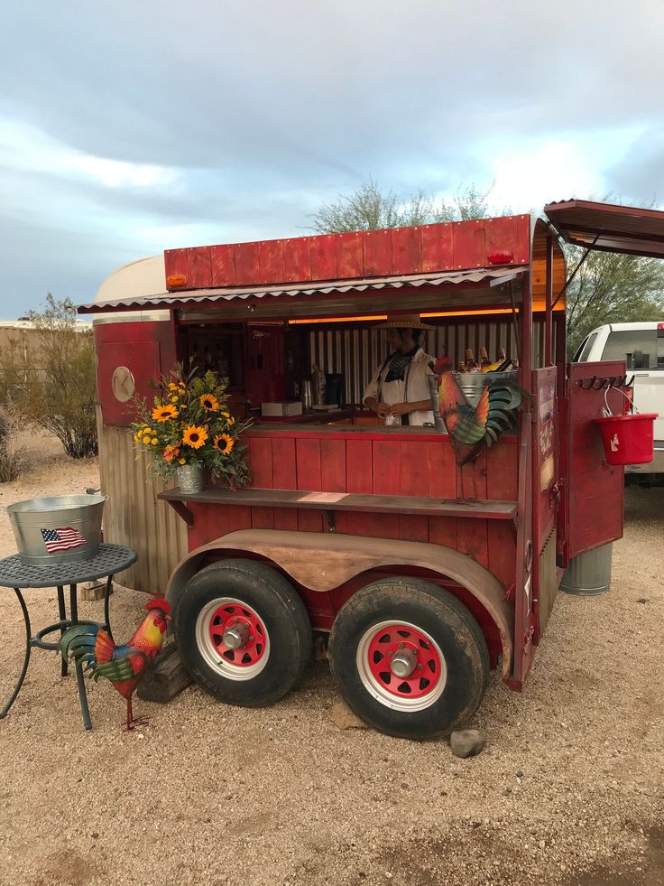 an old fashioned food truck is parked in the dirt