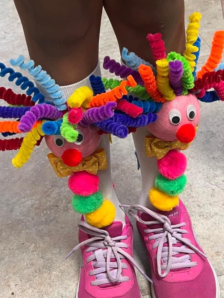 the legs and feet of a person wearing pink sneakers with colorful decorations on their ankles