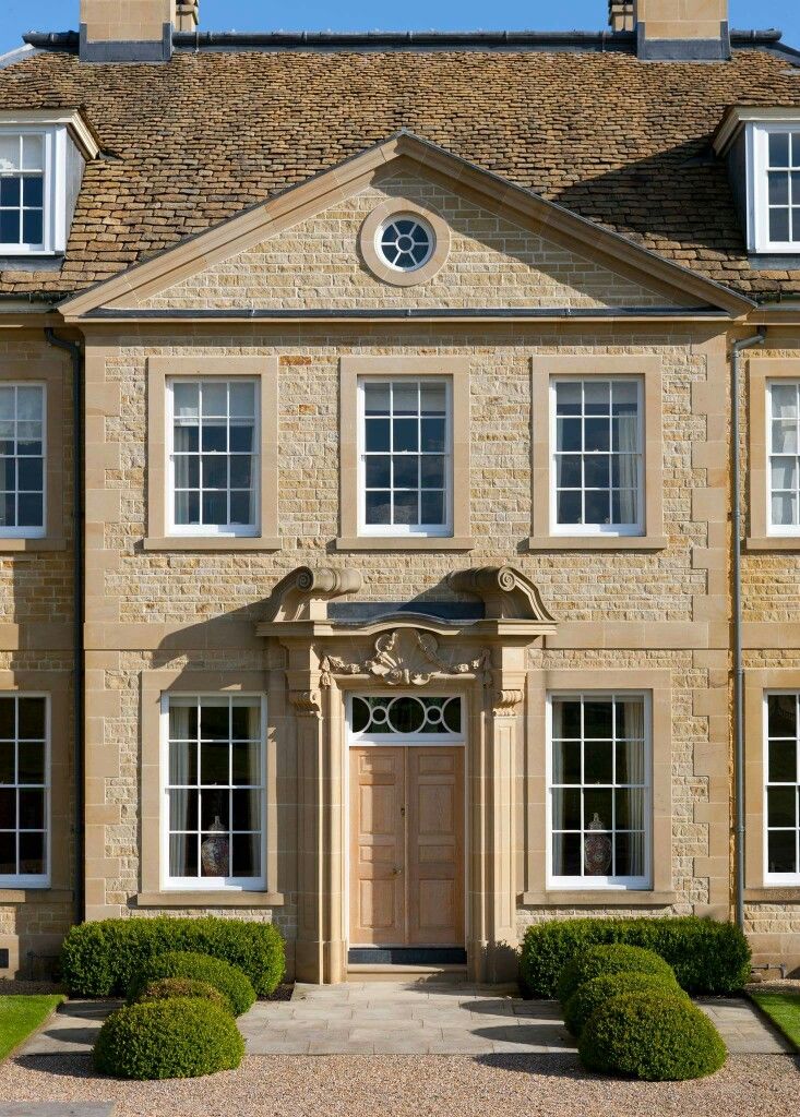 a large stone building with many windows and bushes