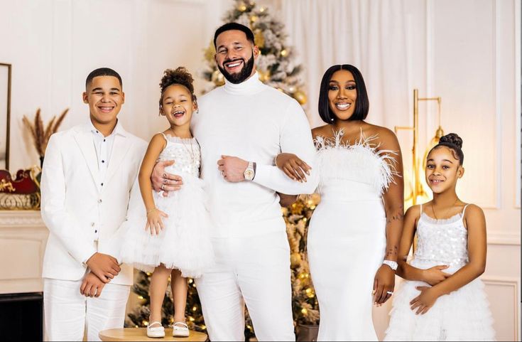 a family posing in front of a christmas tree