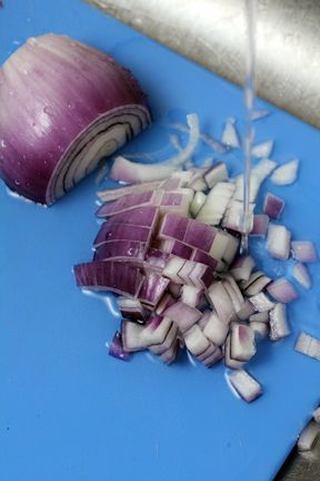 chopped onions are being cut on a blue cutting board