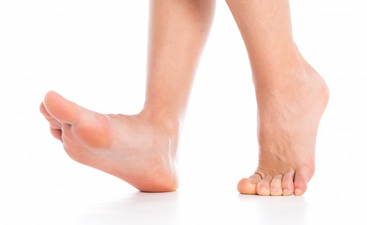 a woman's bare legs and feet are shown against a white background