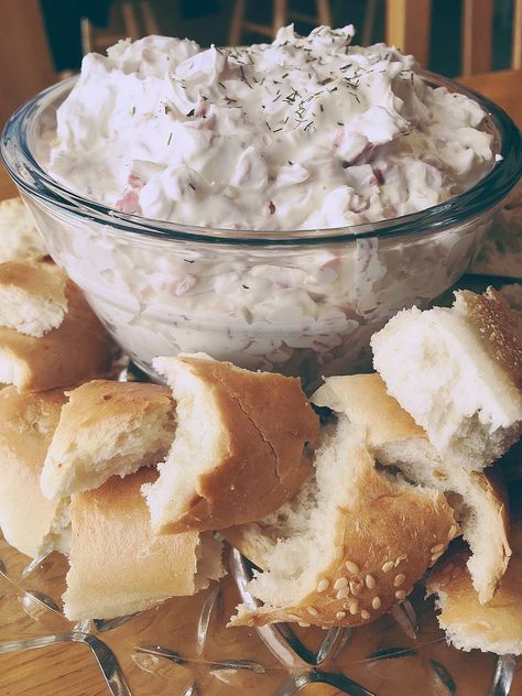 a glass plate topped with rolls covered in cream cheese and sprinkled with sea salt