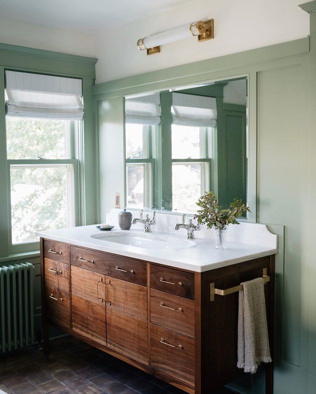 a bathroom with green walls and two sinks