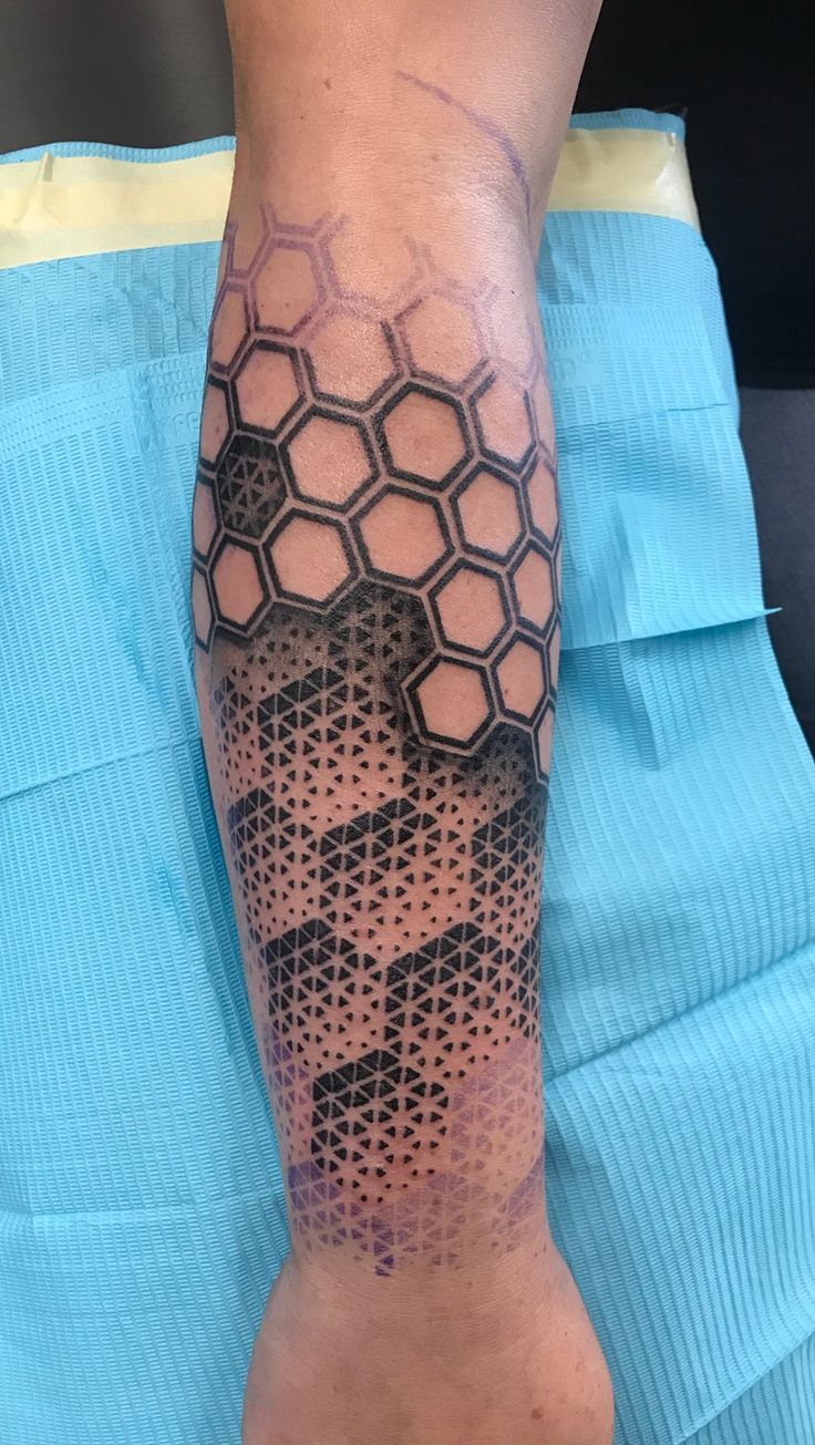 a man with a tattoo on his arm that has hexagons in it