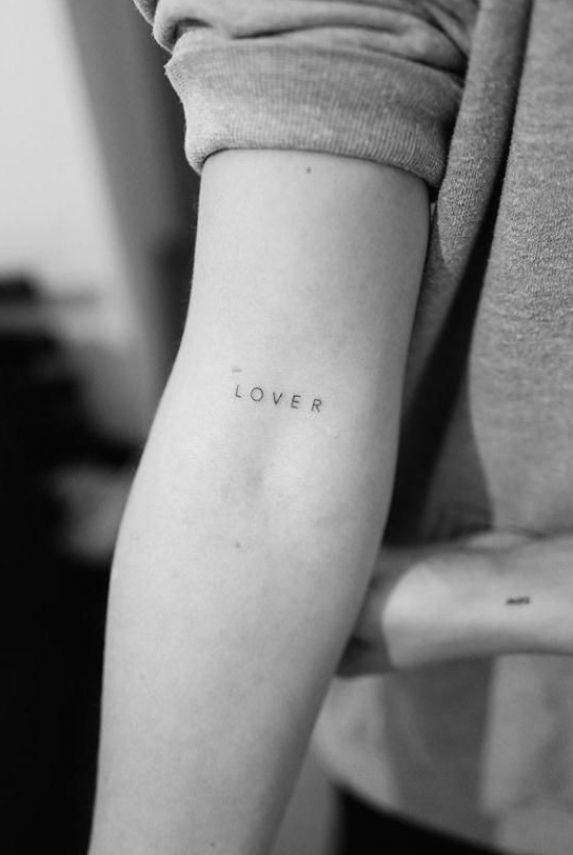 a woman's arm with the word love tattooed on her left arm, in black and white