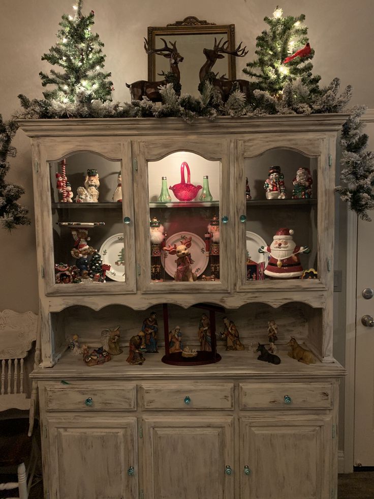 an old china cabinet with christmas decorations on top