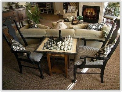 a living room filled with furniture and a chess board on top of a coffee table