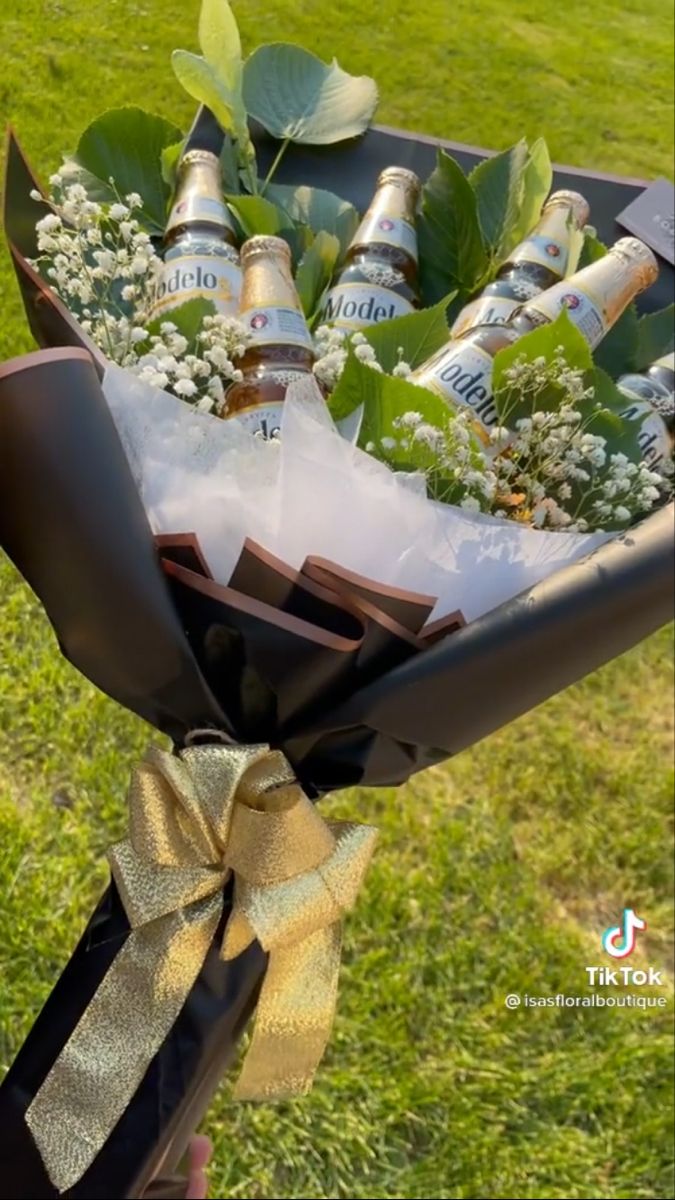 a bouquet of flowers and beer bottles wrapped in paper