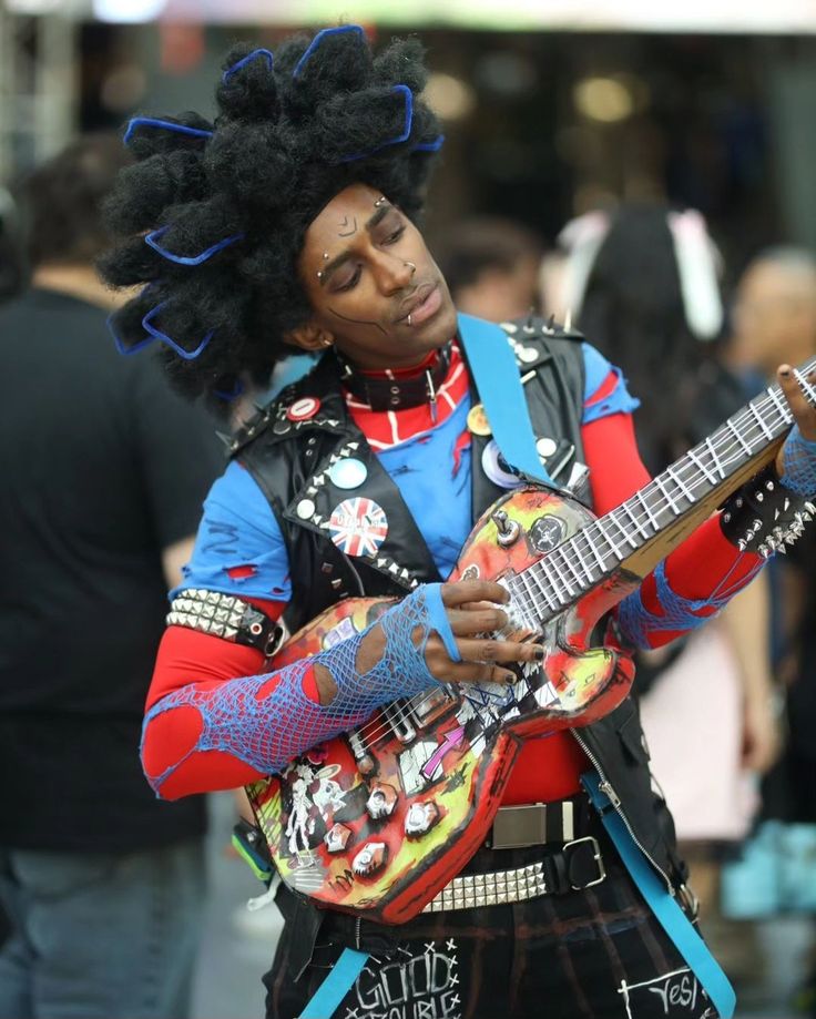 a man with an afro holding a guitar