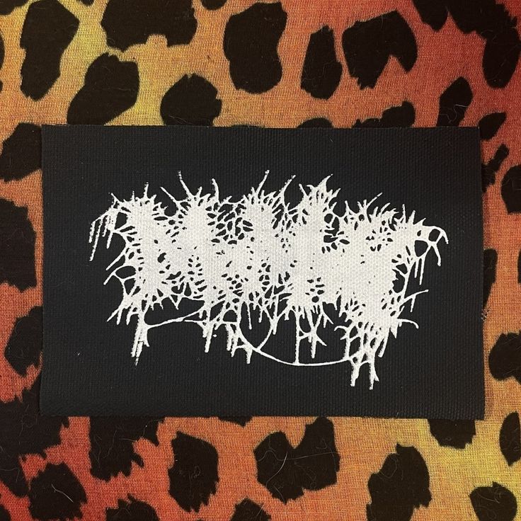 a black and white patch on a leopard print fabric with the word's written in it