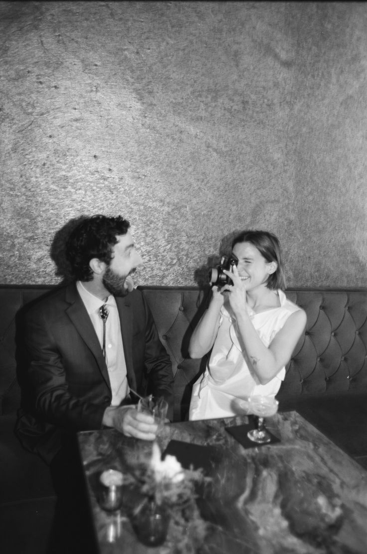 a man and woman sitting next to each other at a table