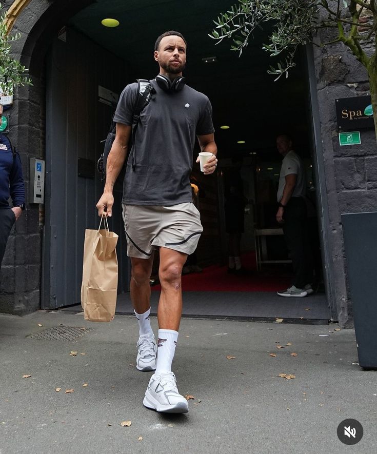 a man walking down the street carrying a brown bag