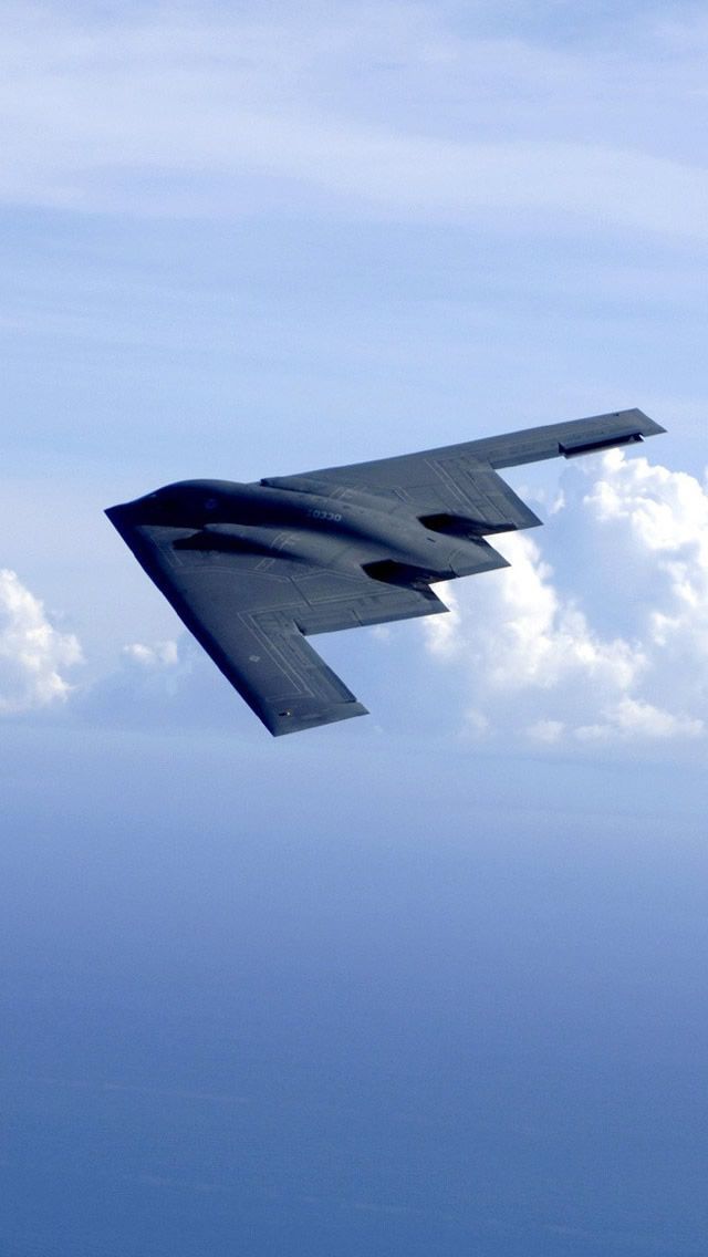 an airplane is flying in the sky with clouds behind it and blue water below them