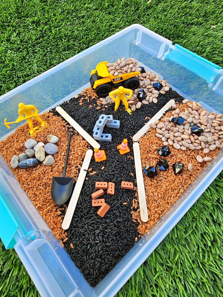 a plastic container filled with dirt and toys