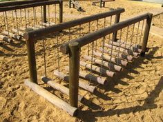 an empty playground with swings and sand on the ground