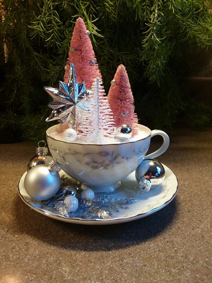 a tea cup decorated with christmas trees and ornaments