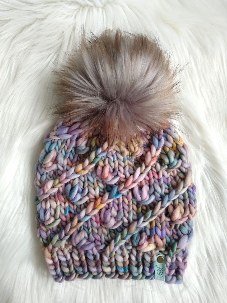 a multicolored knitted hat with a pom - pom on top