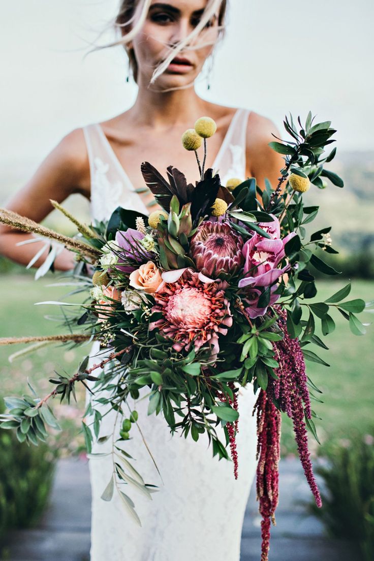 a woman holding a bouquet of flowers in her hands