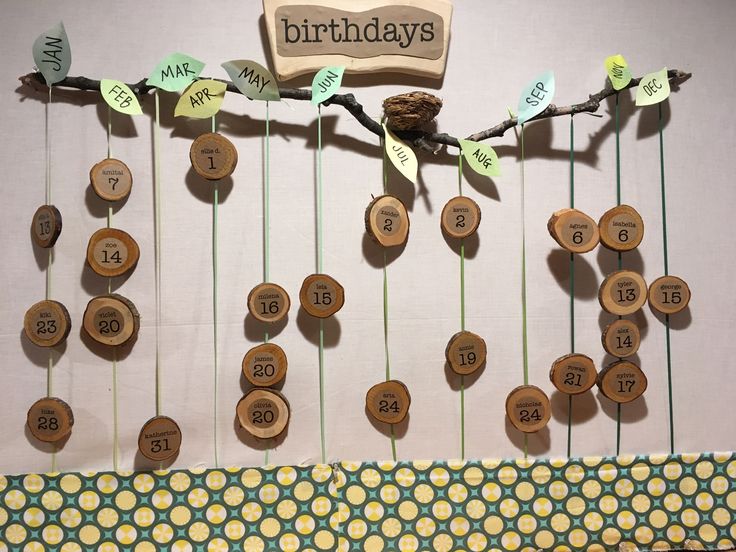 a bunch of wooden buttons hanging from a tree branch with the words happy birthday written on them