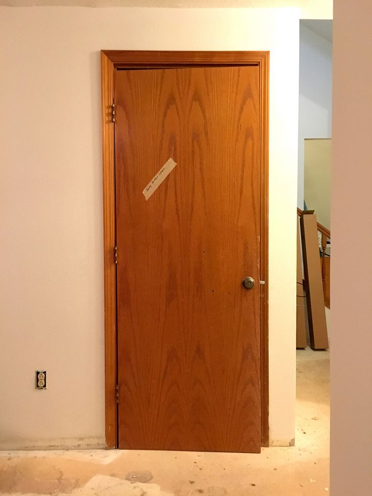 an empty room with a wooden door in it