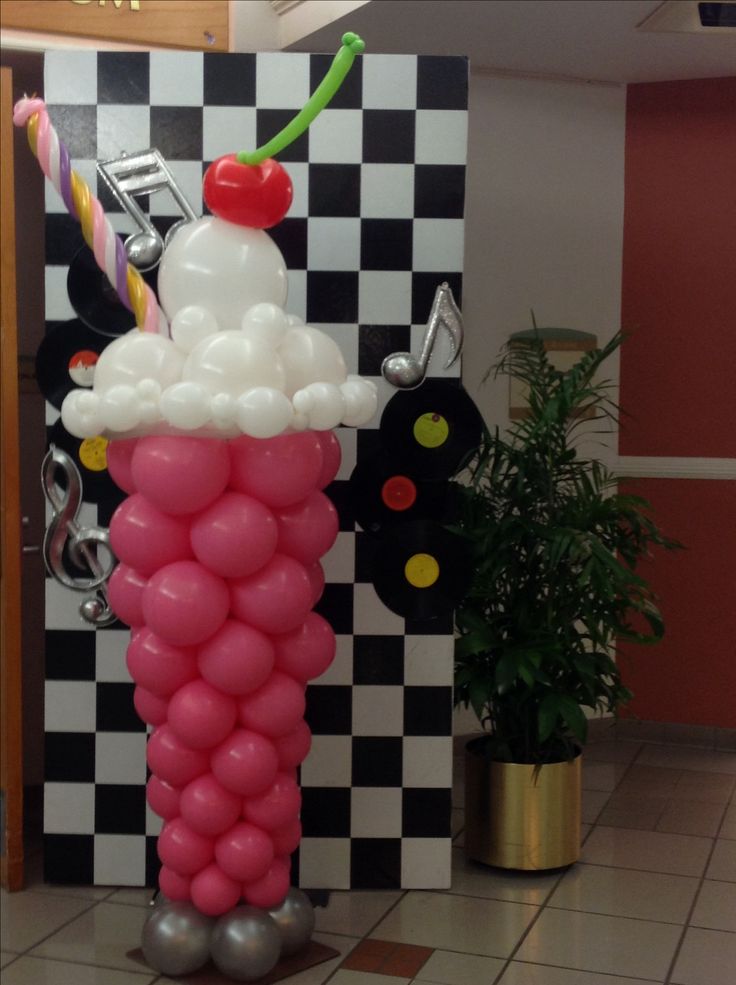 a balloon sculpture in the shape of a ice cream cone with a cherry on top