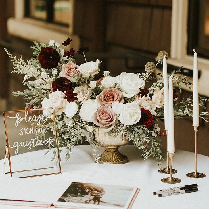 an arrangement of flowers and candles on a table