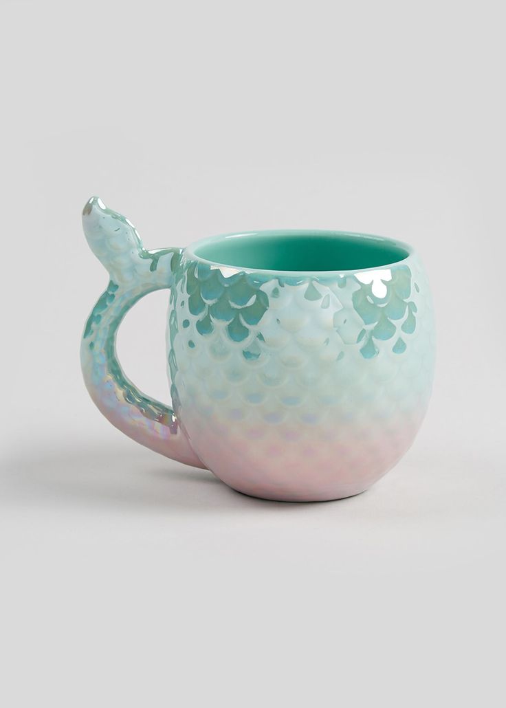 a ceramic mug with a mermaid tail on the inside and green undergluste