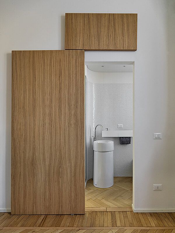 an open door leading to a bathroom with wooden floors