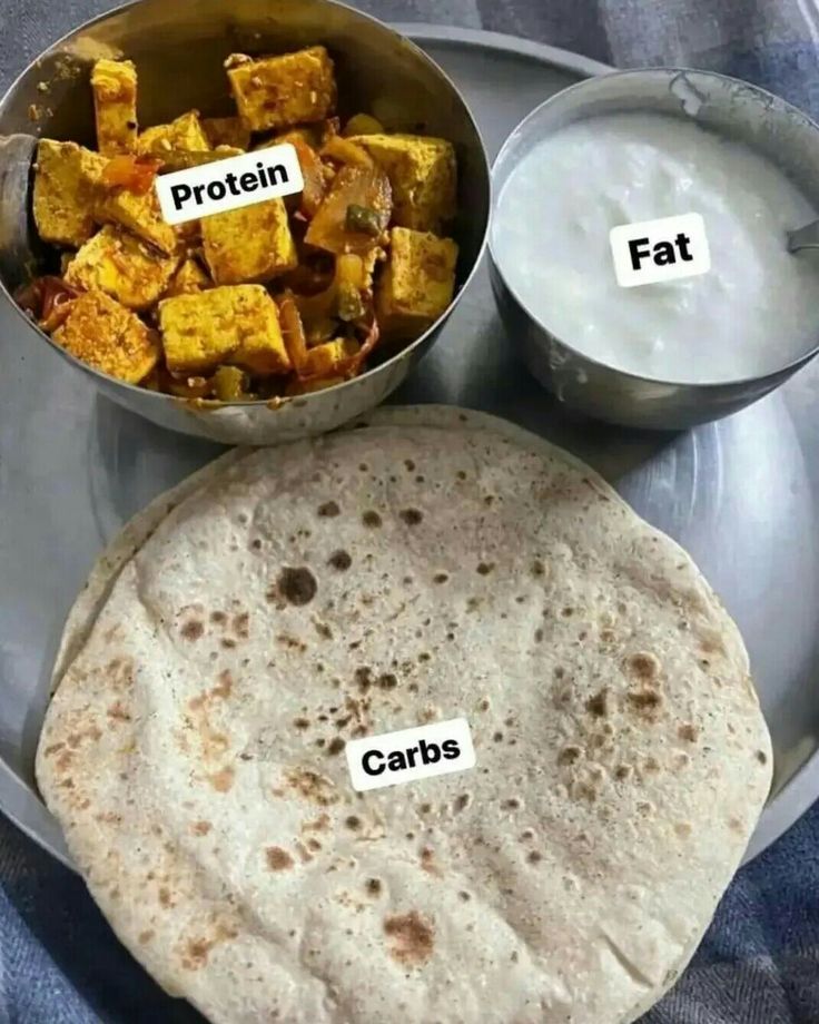 a metal plate topped with food next to two bowls filled with milk and bread on top of it