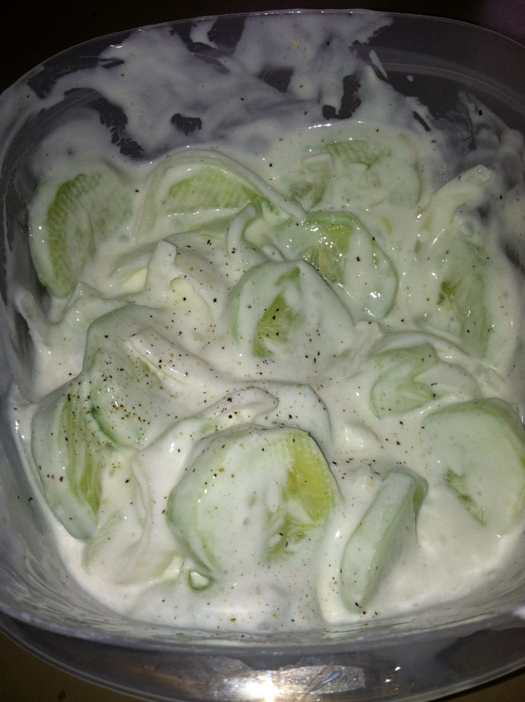 cucumbers and cream in a glass dish on a table