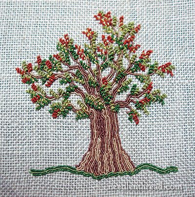 a cross stitched picture of a tree with red berries on it