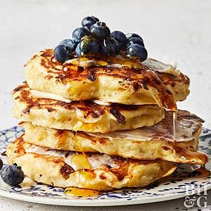 a stack of pancakes with blueberries and syrup